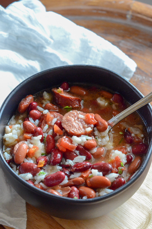 red beans and rice with canned beans in black bowl with white napkin