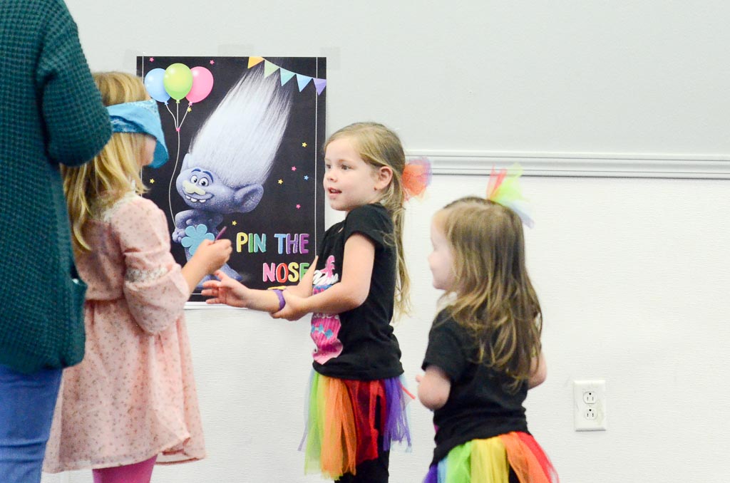 kids take turns playing Trolls party games at a birthday party