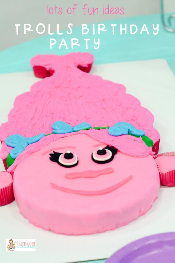 pink Poppy Trolls cupcake cake with Troll hair cupcakes attached and text overlay on image 