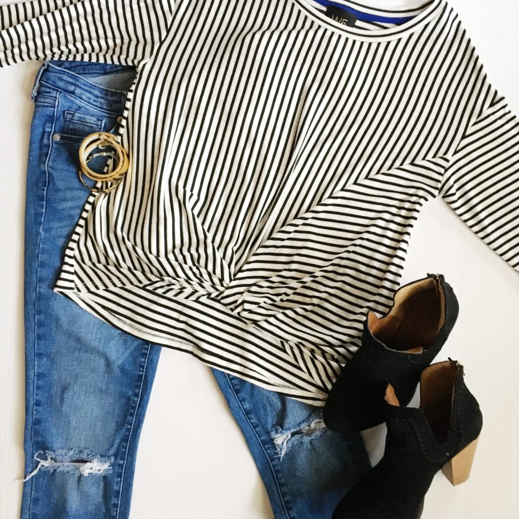 flay lay image with black and white striped shirt, black booties and jeans 