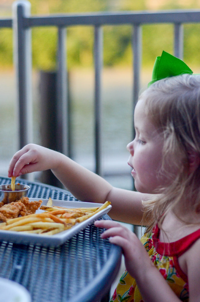 little girl eating fries and chicken