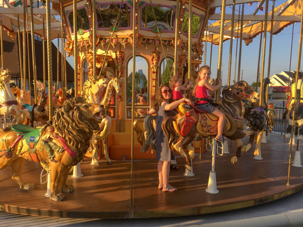 mom and daughter ride the carousel on the Branson Strip 