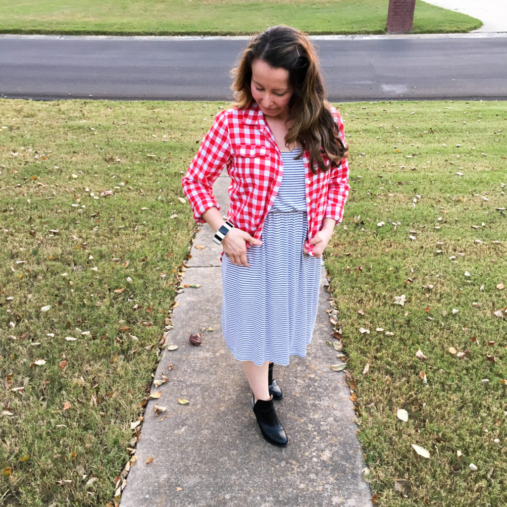 teacher wearing red plaid blouse over striped dress as a back to school outfit 