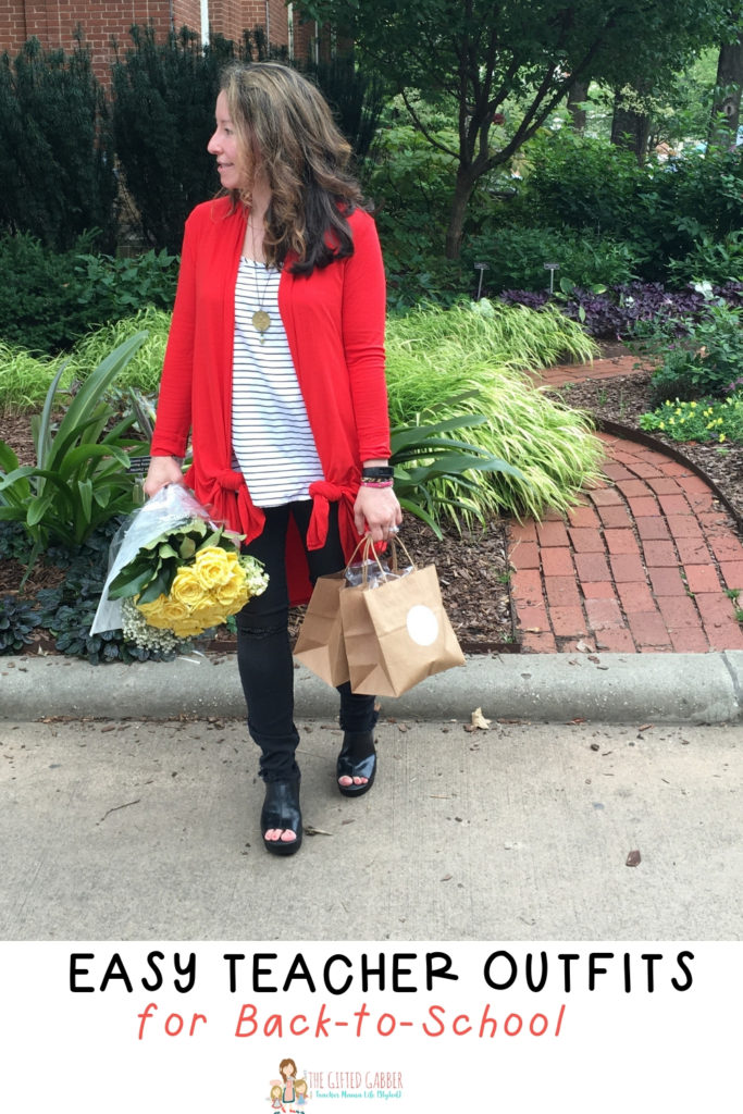 teacher holds bouquet and wears red oversized sweater and black pants for her back to school outfit