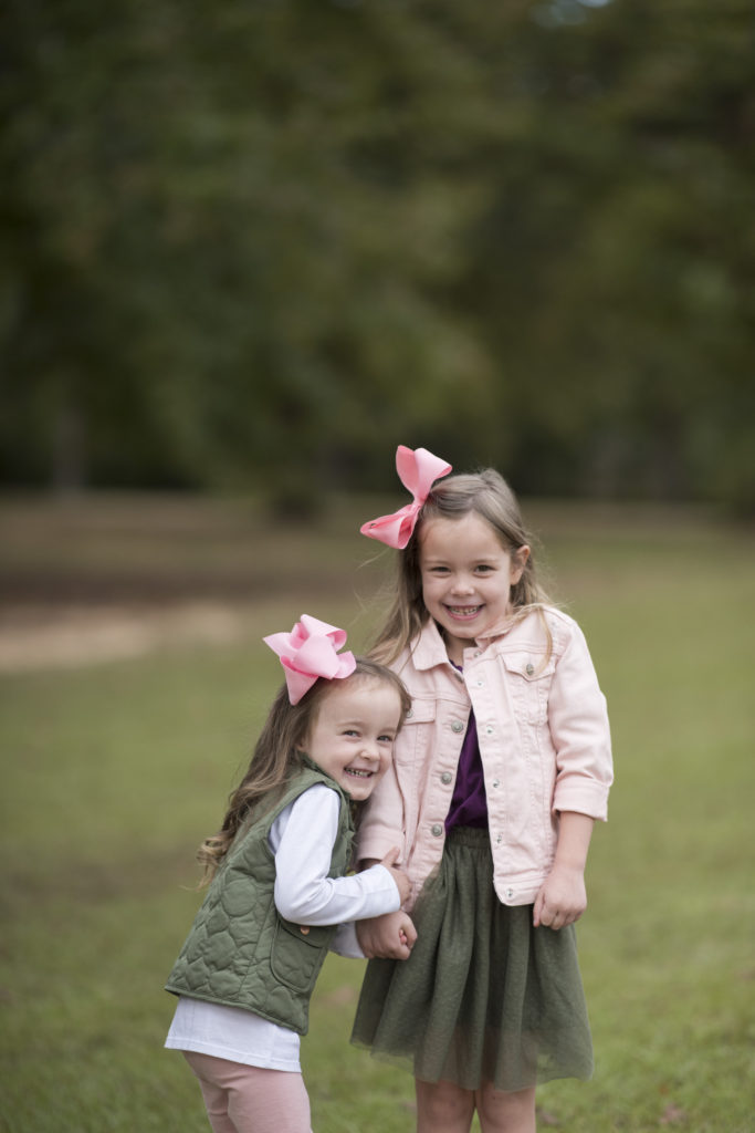 fall family pictures with sisters in matching clothing of pink and green 