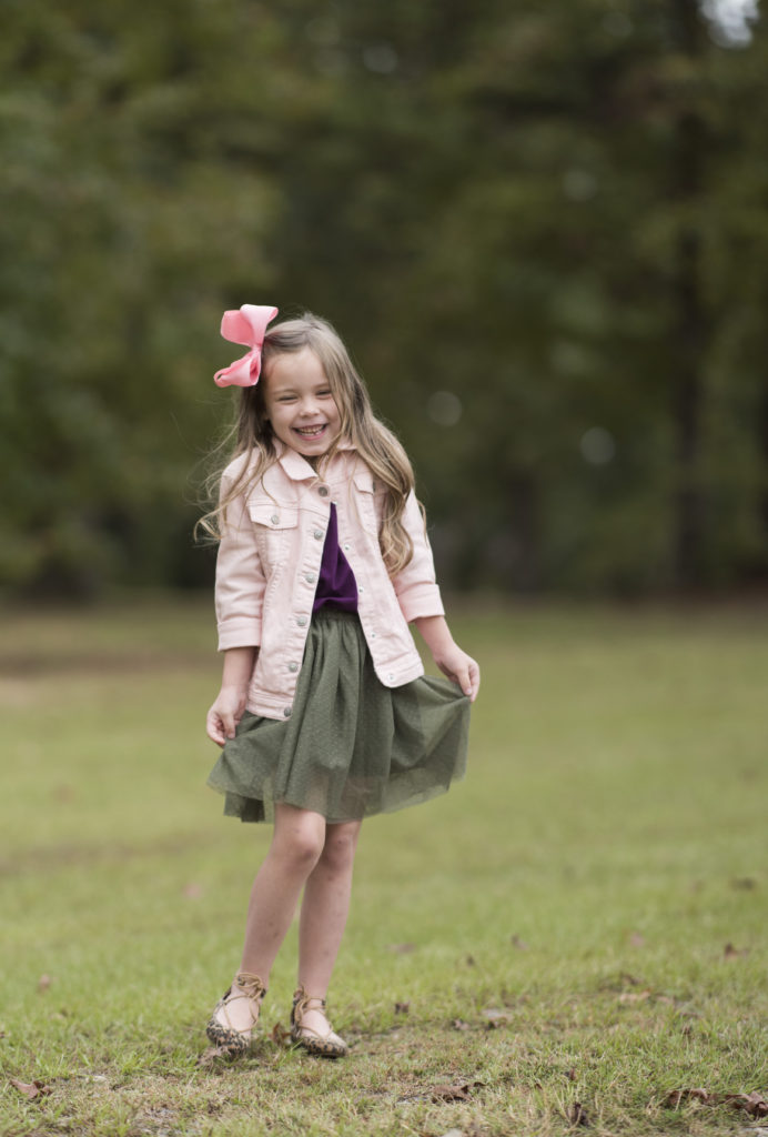 fall family pictures of girl wearing olive green skirt and pink denim jacket 