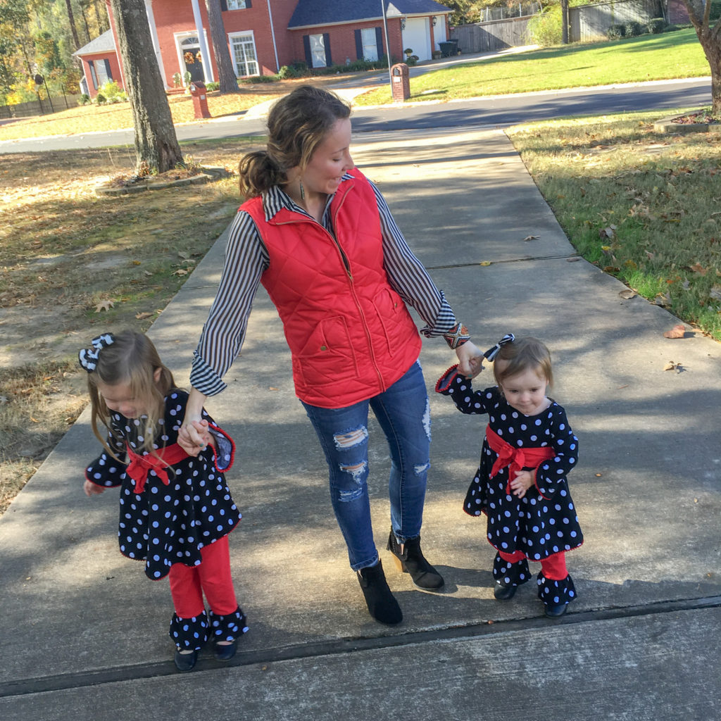 mom and two daughters in coordinating black and red outfits and red puffer vest outfit