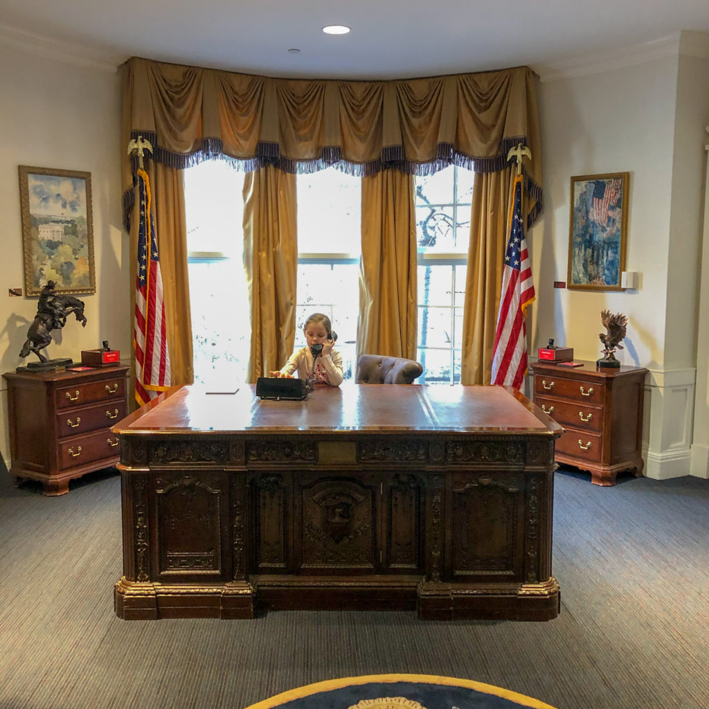 little girl sits in "Oval Office" at Magic House - Children's Museum of St. Louis 