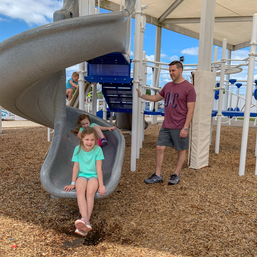 father and children play at RIVERSPORT Youth Zone and playground in OKC
