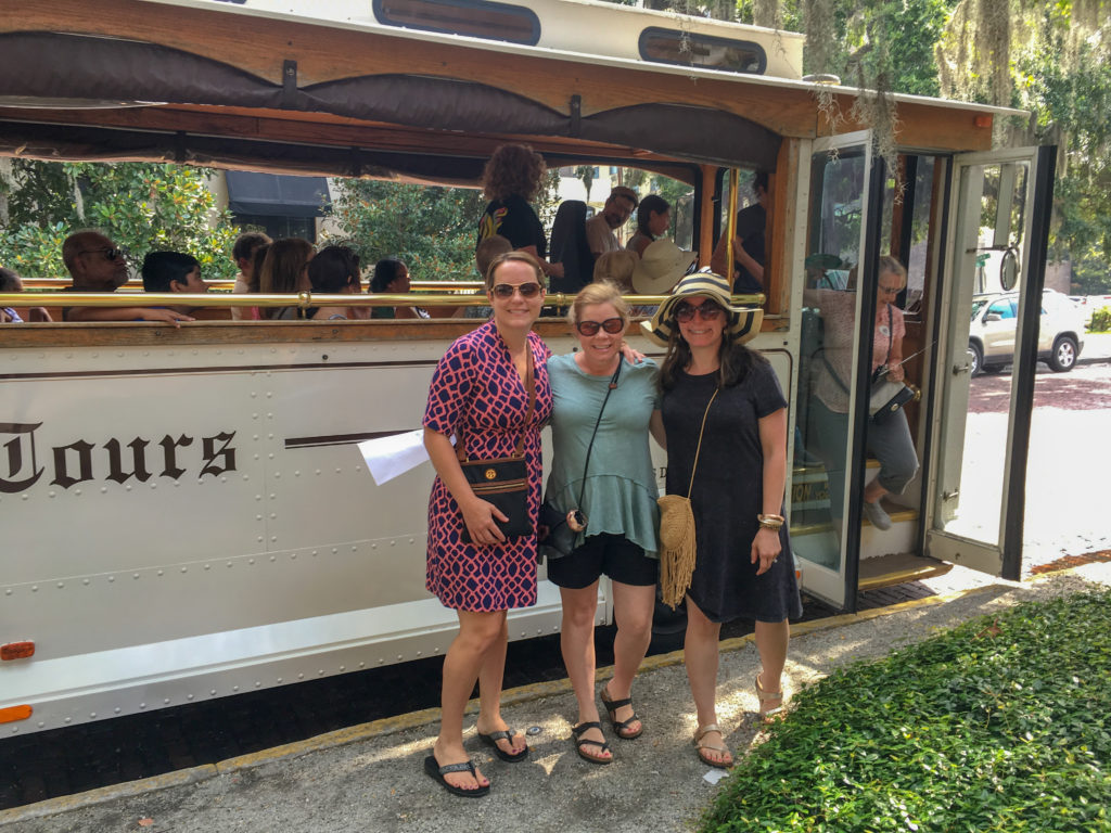 three women stand in front of an Old Savannah Trolley during a girls weekend in Savannah (Savannah Georgia road trip)