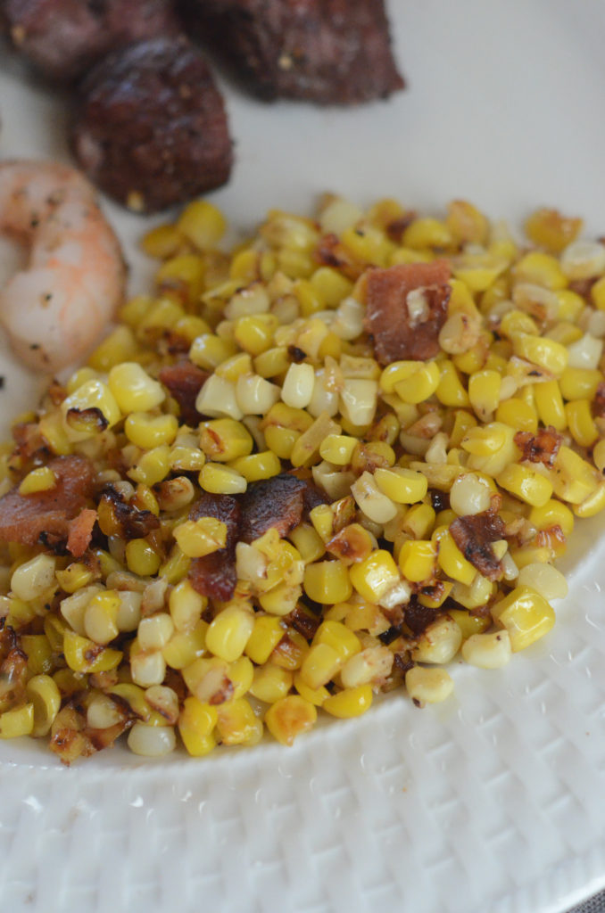 skillet corn with bacon on white plate