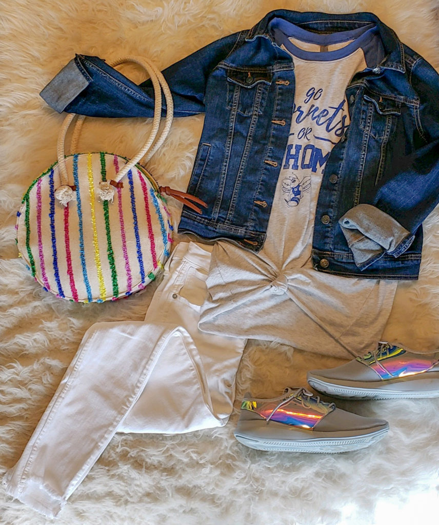 jean jacket with school spirit t-shirt, white jeans, metallic tennis, and colored circle bag
