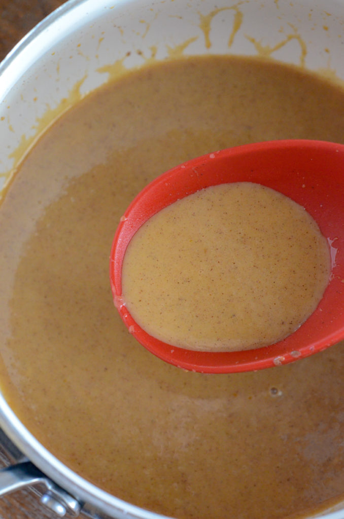 cinnamon pumpkin glaze in red ladle on stove