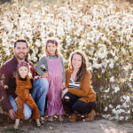 family sits in front of cotton field in cotton field family photos