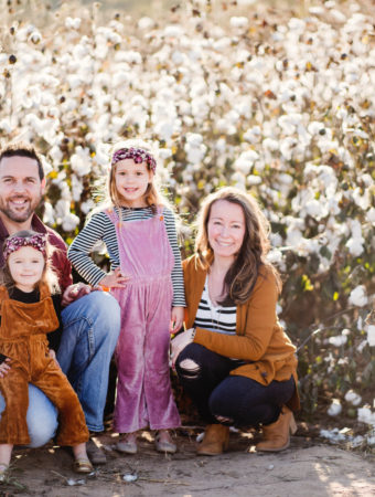 family sits in front of cotton field in cotton field family photos