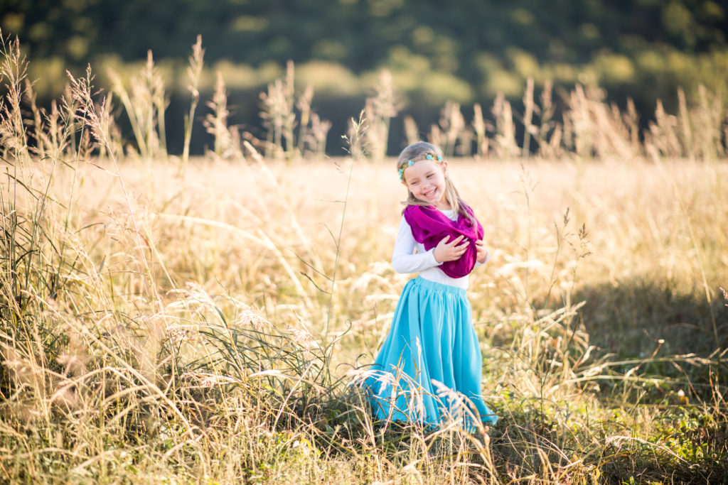 little girl poses in boho chic outfit in field