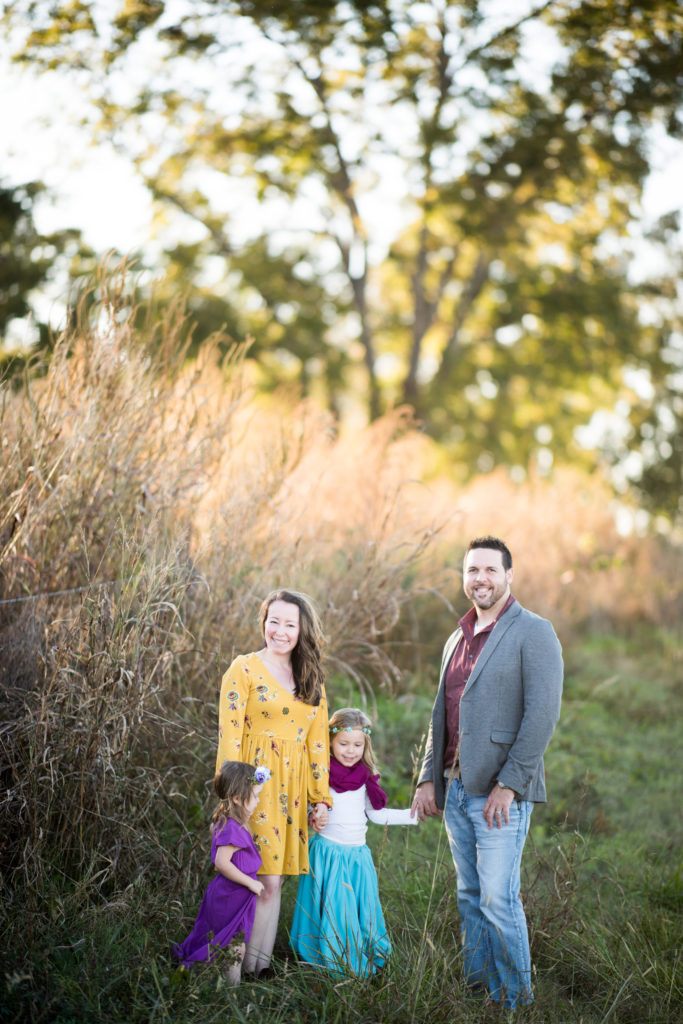 family poses in field with boho chic outfits