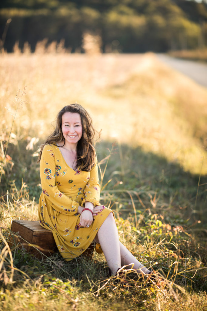 woman wears boho dress in field for fall photos
