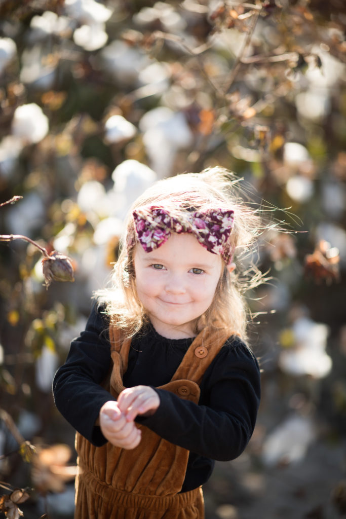 little girl in brown romper at Schaefer's Pumpkin Patch and Corn Maze