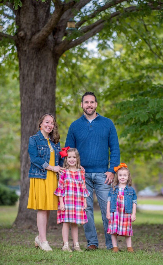 a family in navy blue and mustard outfits with plaid dresses