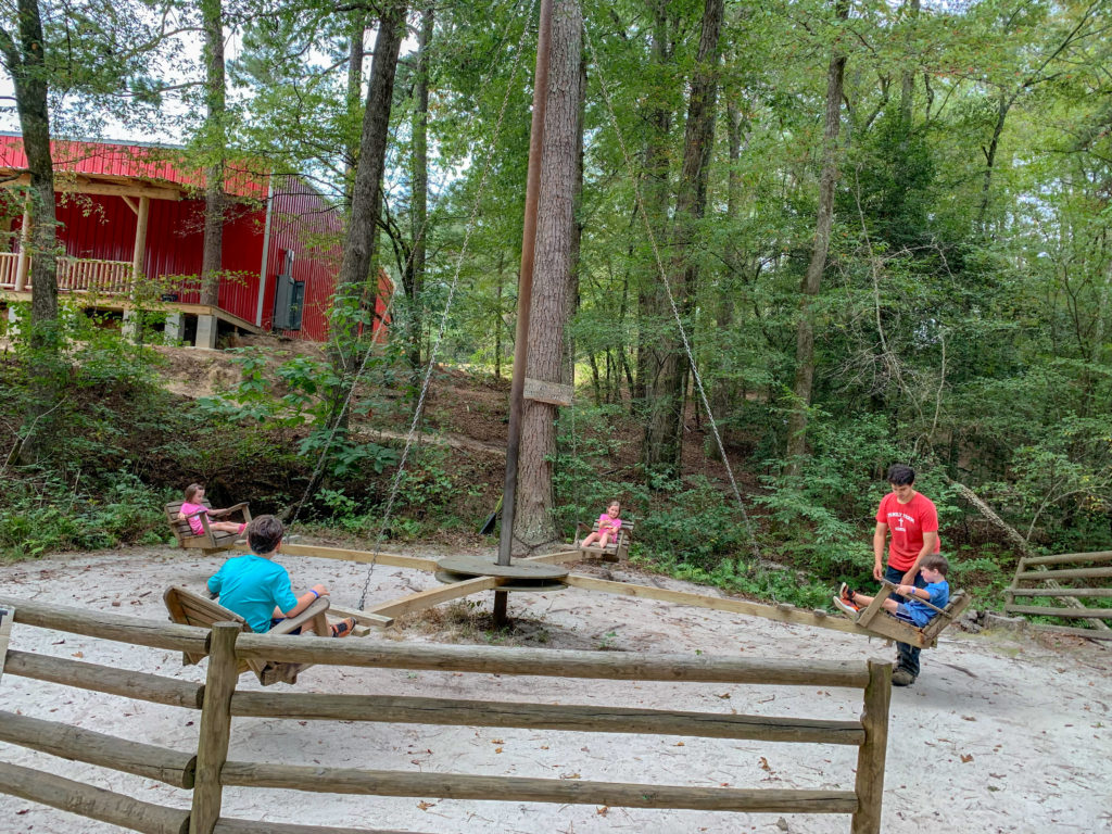 children ride on rustic swing for kids at Family Farm in Malvern, Arkansas