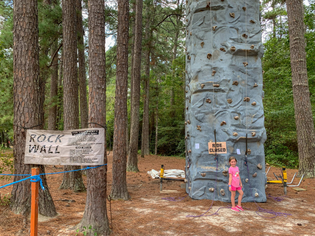 child stands in front of rock wall at Family Farm in Arkansas