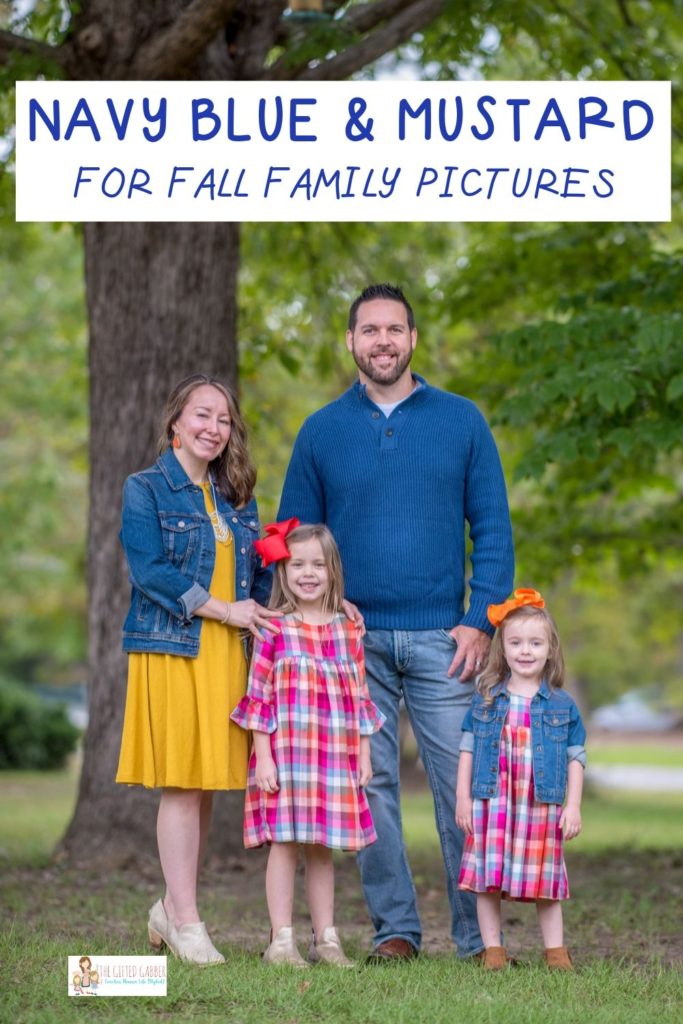 a family in navy blue and mustard smile during a fall family photoshoot