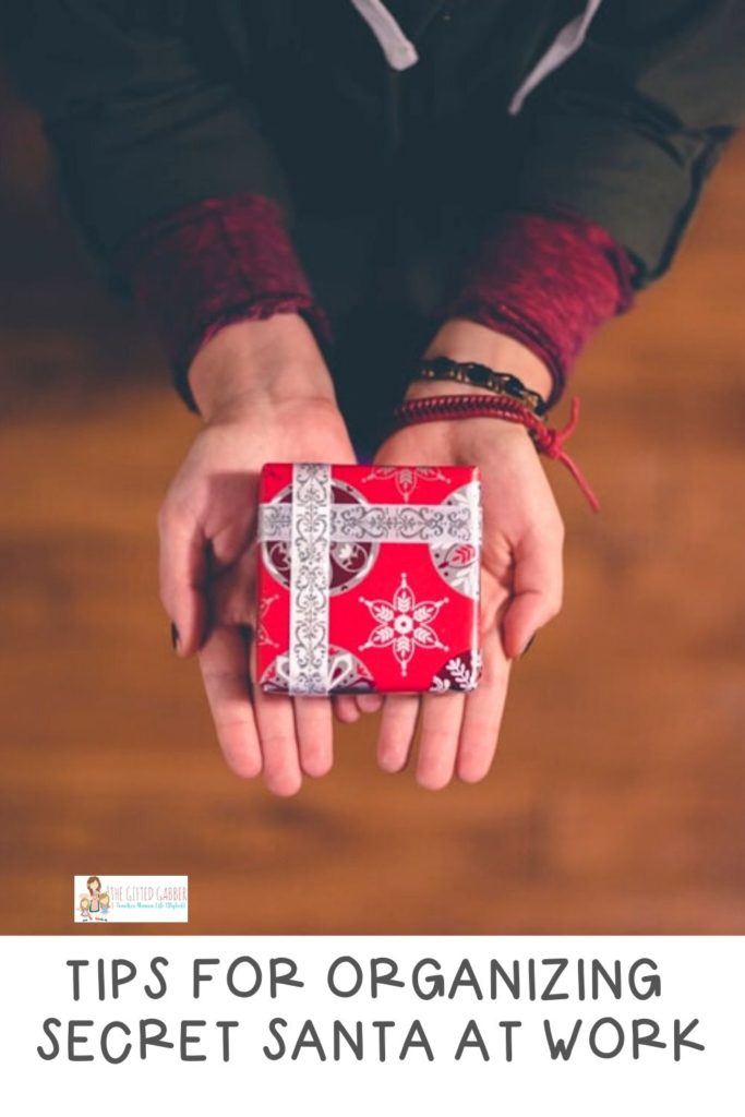 woman holds a small wrapped gift in hands