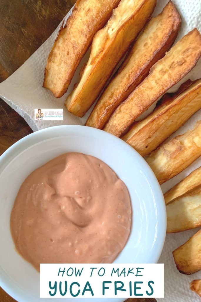 yuca sauce in white bowl with fried yuca fries in background