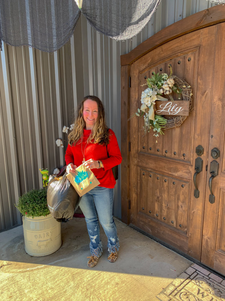 woman holds packages in front of Lily Pad Boutique in Des Arc, AR