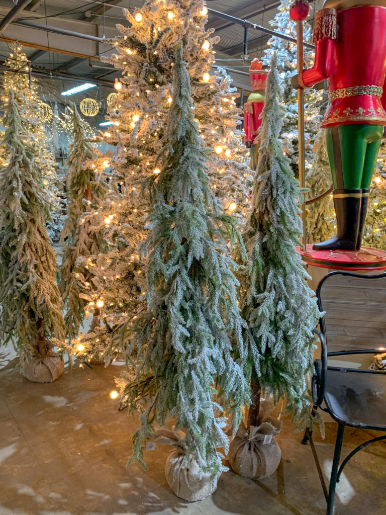 thin Christmas trees flocked in a burlap bucket