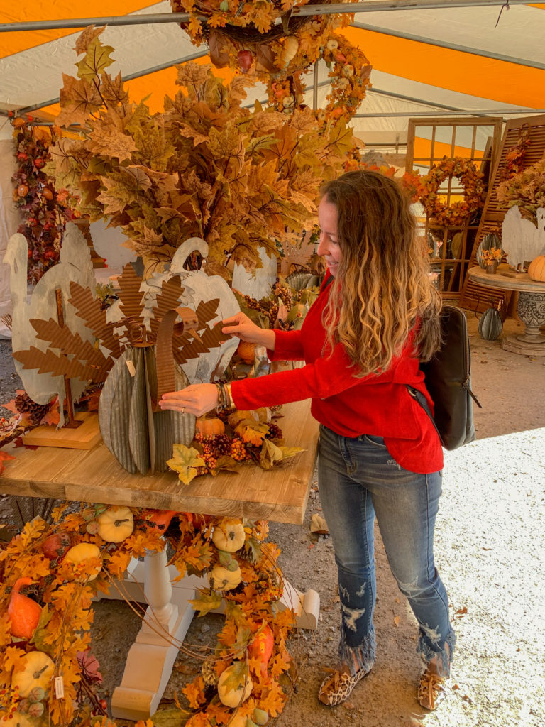 woman in red sweater explores fall decor at Guess and Company in Des Arc, AR