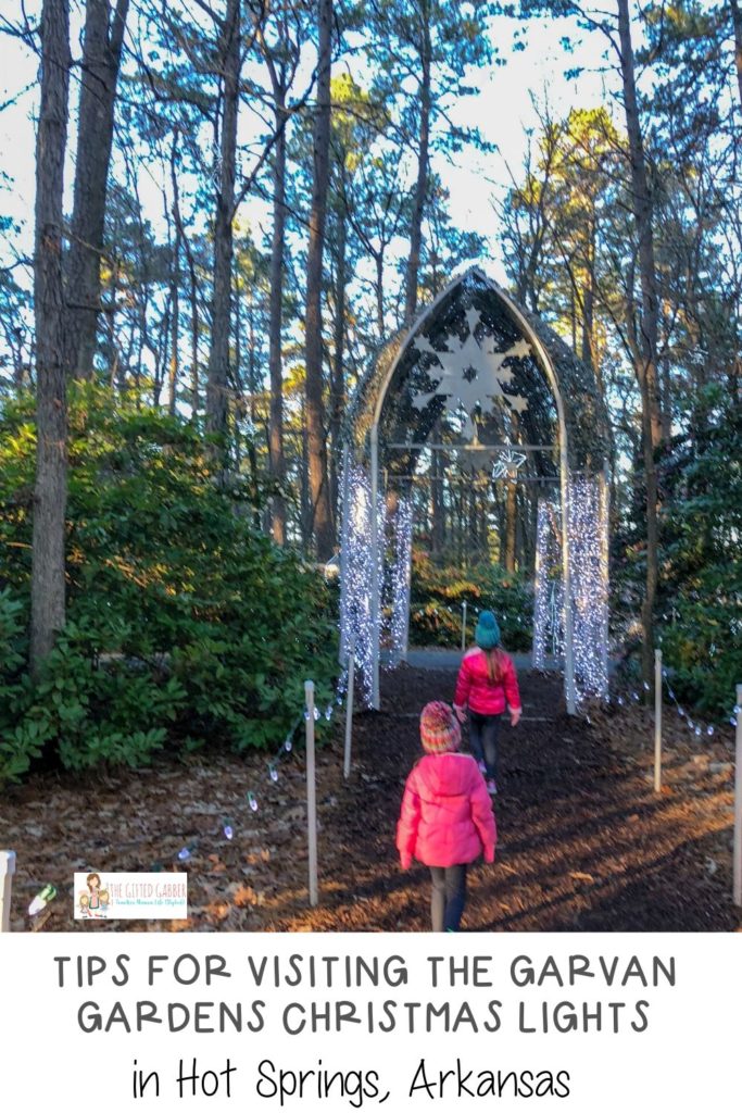little girls walk through Garvan Gardens Christmas lights with text overlay