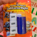 lady holds Left Center Right (LCR) game to be used in Dirty Santa