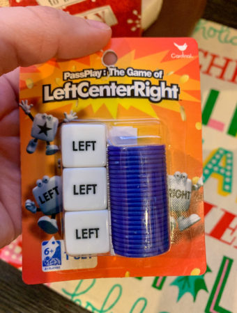 lady holds Left Center Right (LCR) game to be used in Dirty Santa