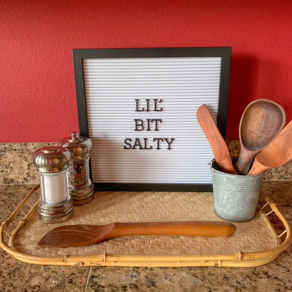 funny food captions - "Lil' bit salty" on letter board sign with salt shaker and mixing spoons
