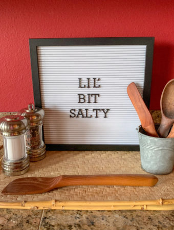 funny food captions - "Lil' bit salty" on letter board sign with salt shaker and mixing spoons