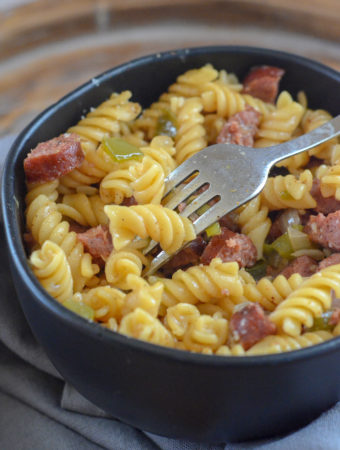 black bowl of Cajun pasta jambalaya with sausage on gray napkin