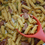 Cajun pastalaya in skillet with big red serving spoon