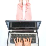 woman in coral pants sits on floor with laptop on lap and text overlay