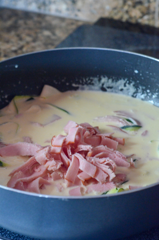 deep black skillet with alfredo sauce and ham 