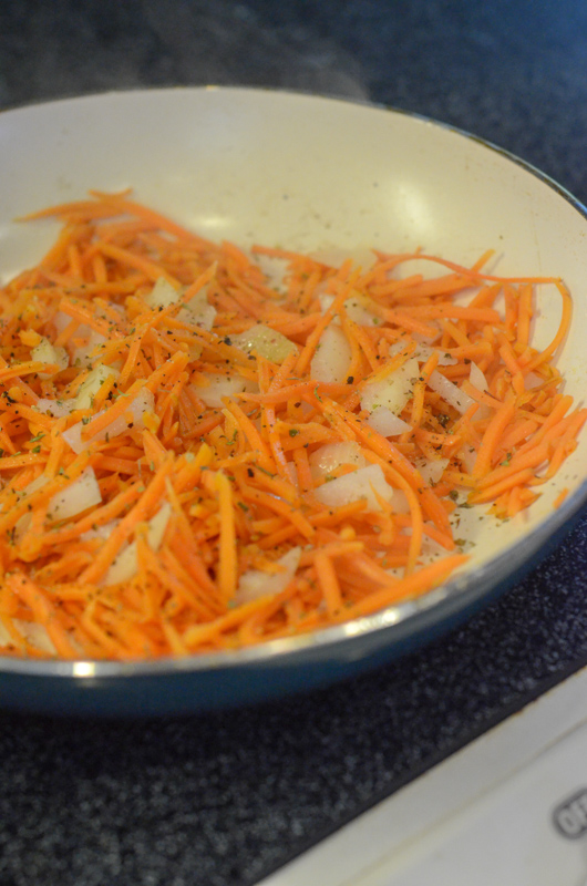 carrots sauteed with onions in small white pan