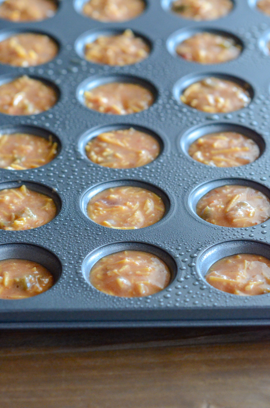 uncooked egg and cheese mixture for chili con queso muffin cups in mini muffin tin