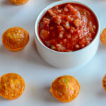 white serving platter with chili con queso egg cups and cup of salsa