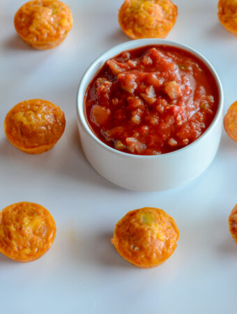 white serving platter with chili con queso egg cups and cup of salsa
