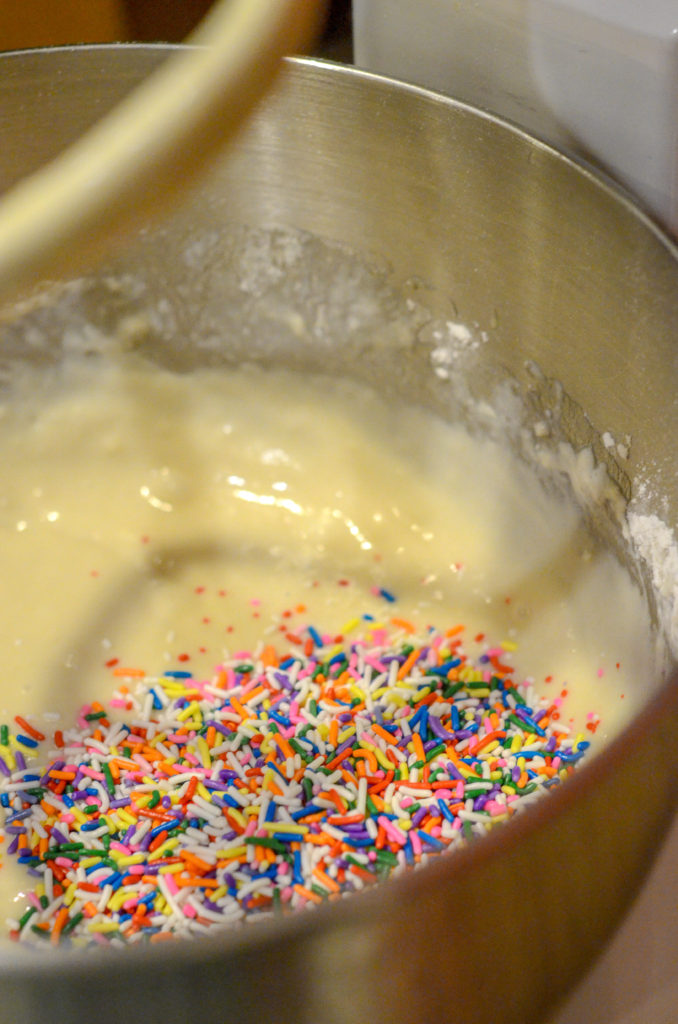 funfetti waffles batter in bowl of mixer with sprinkles