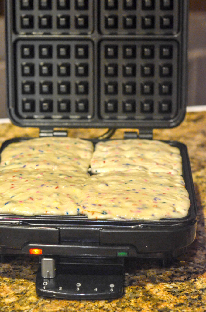 batter for birthday cake waffles in waffle maker before cooking