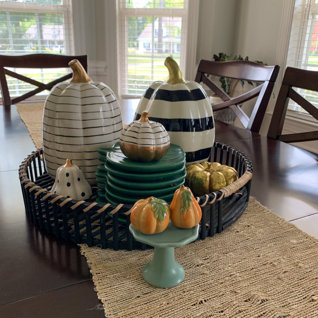 a simple fall display on dining table with ceramic pumpkins in a black tray