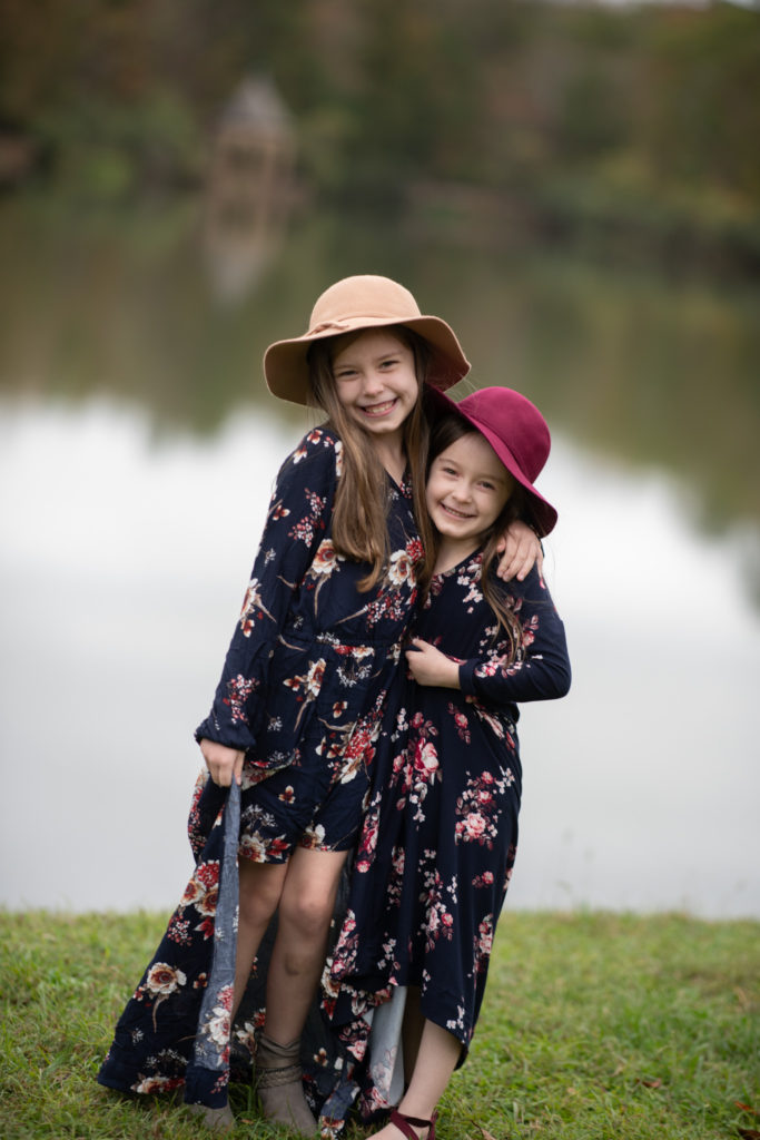 zwei Schwestern in aufeinander abgestimmten floralen Burgunder- und Marineoutfits