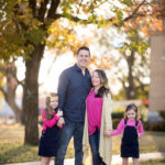 family of four in navy and pink outfits for family pictures